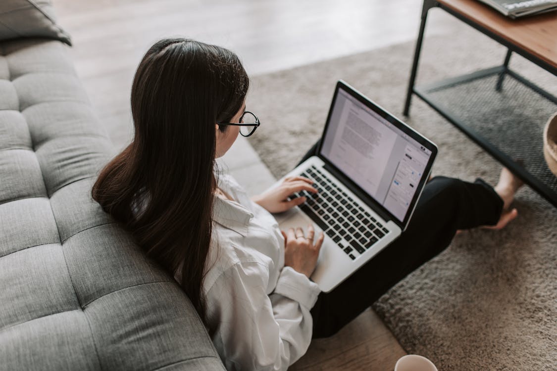 Woman working on a laptop from home, illustrating common posture habits during remote work